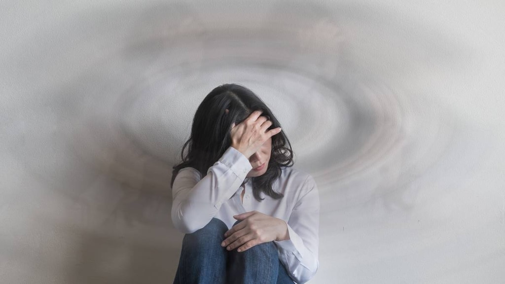 Women with POTS feeling dizzy and sitting with knees to chest.