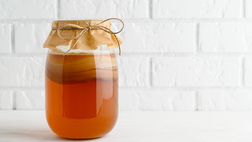 Jar of kombucha with floating SCOBY.