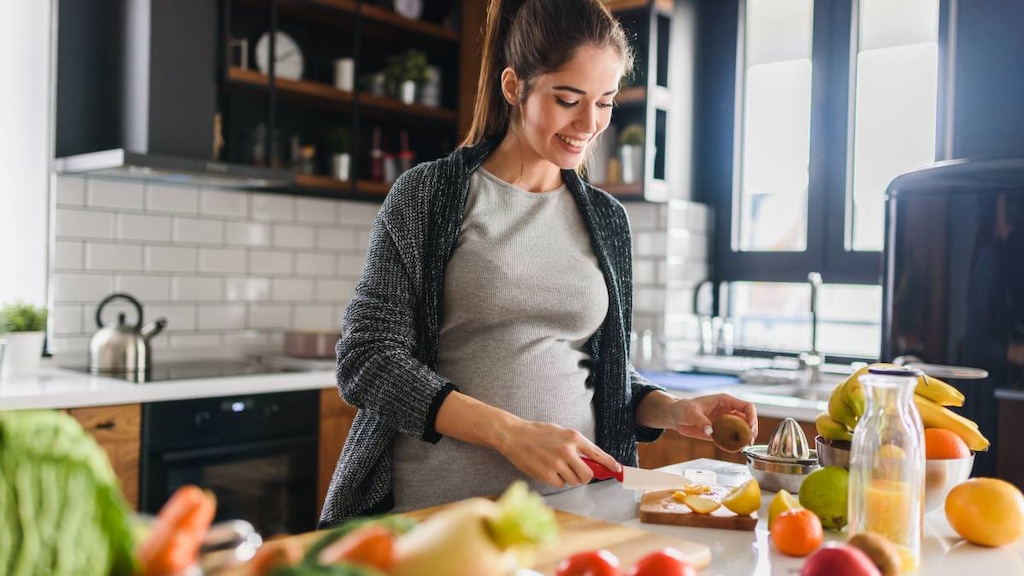 Pregnant woman preparing healthy fresh food.