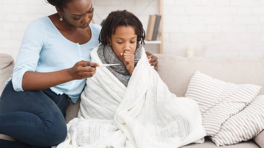 Sick child with cough and mother taking temperature.