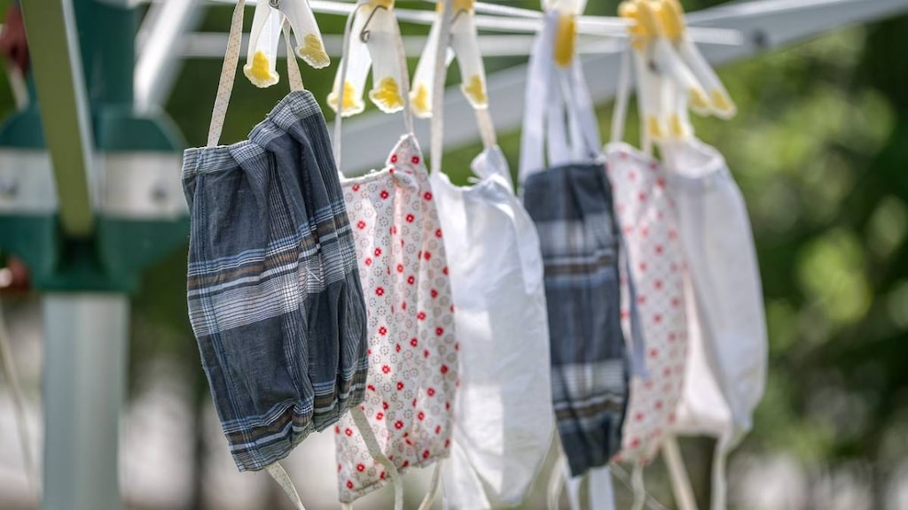 Reusable cloth masks drying on a clothesline in the sun