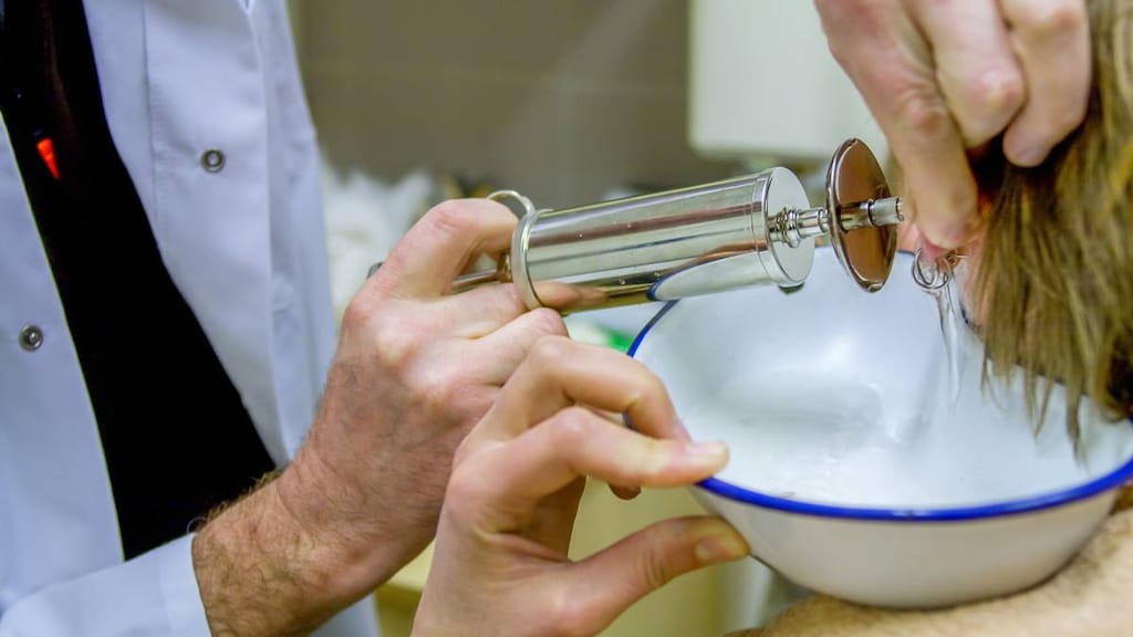 Doctor treating ear with water