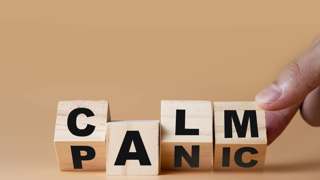 Hand flipping wooden cubes for change wording&quot; Panic &quot; to &quot; Calm&quot;.image