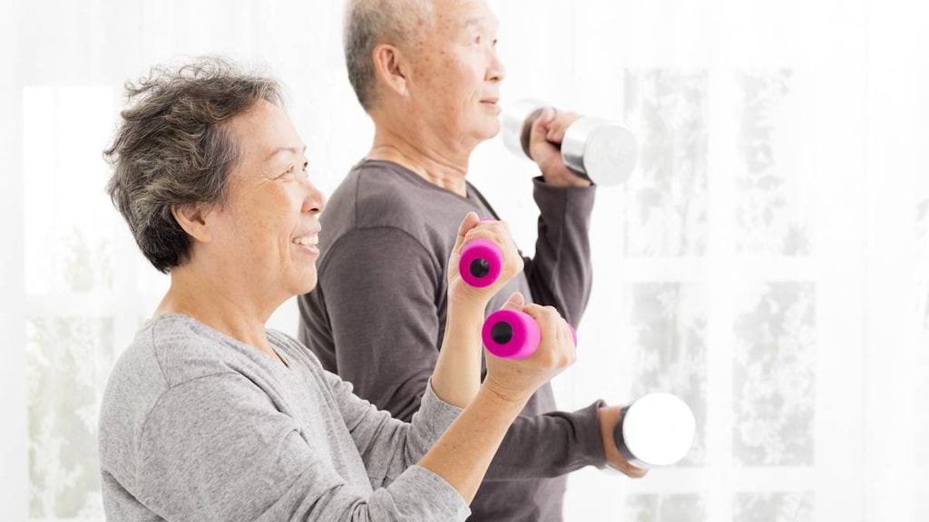 Happy senior couple exercising with dumbbells.