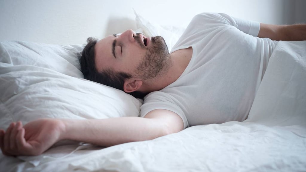 Man sleeping in his bed and snoring loudly credit: tommaso79.image