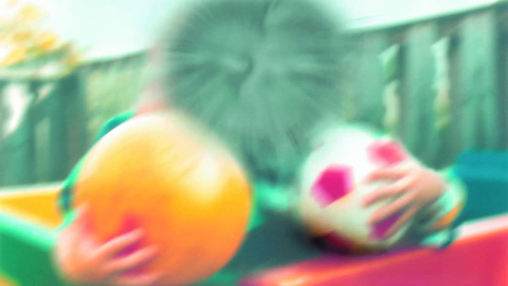 Blurred image of child holding balls