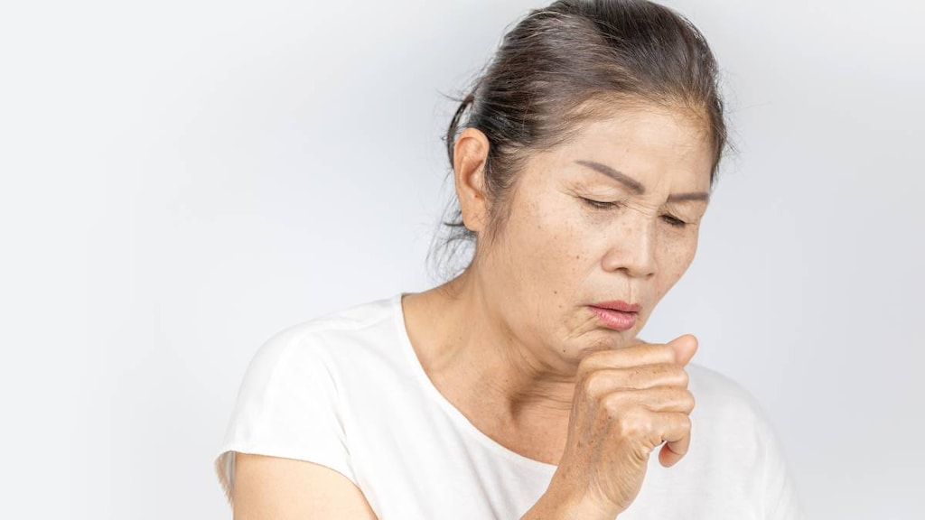 An older woman coughing