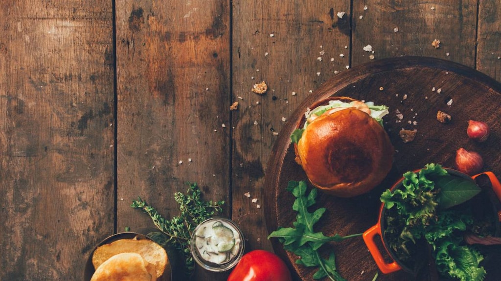 wooden background with bread and vegetables arranged on it in the right bottom.image