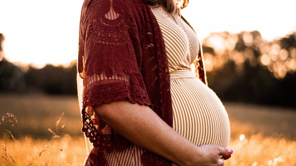 Pregnant woman in front of field