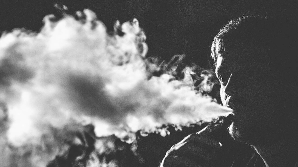 Person blowing out vaping smoke