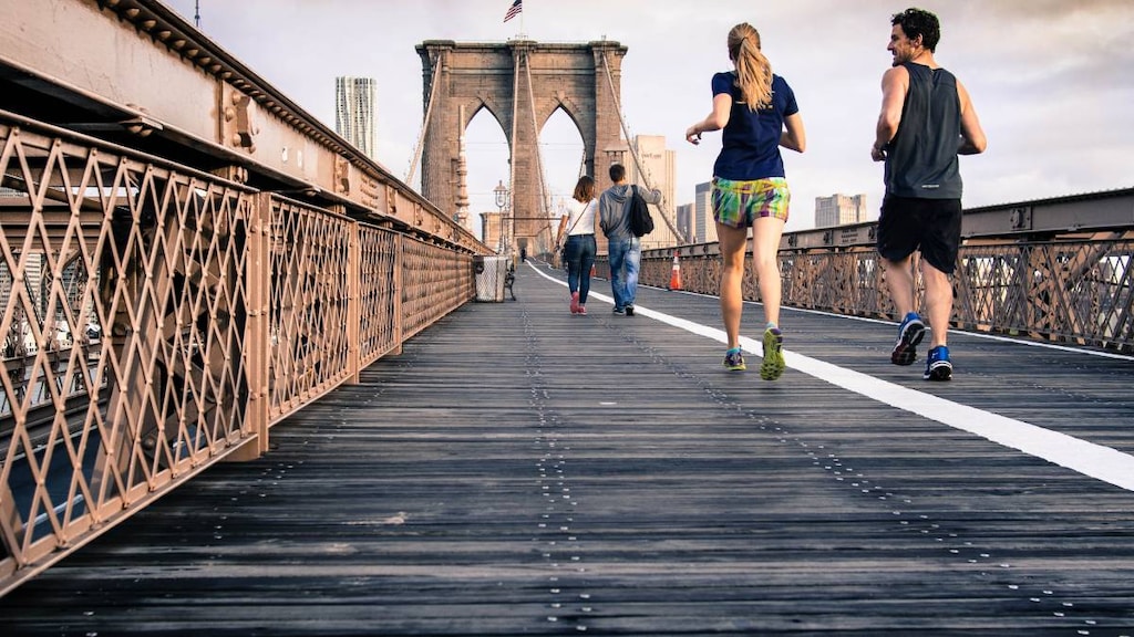 People running down a bridge.