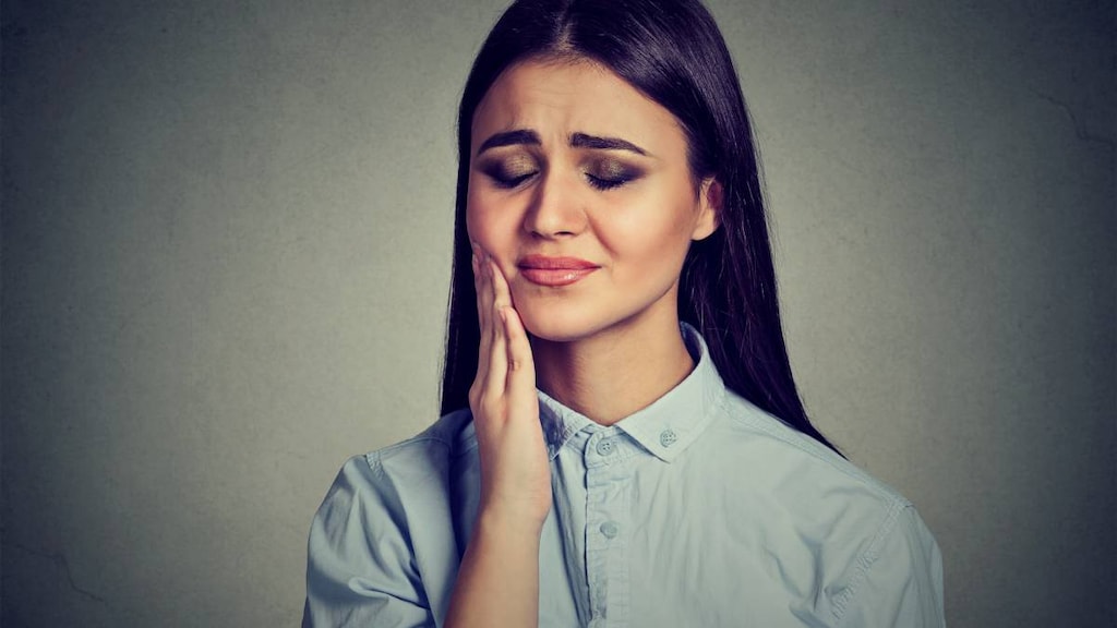 Woman in pain with hand on jaw